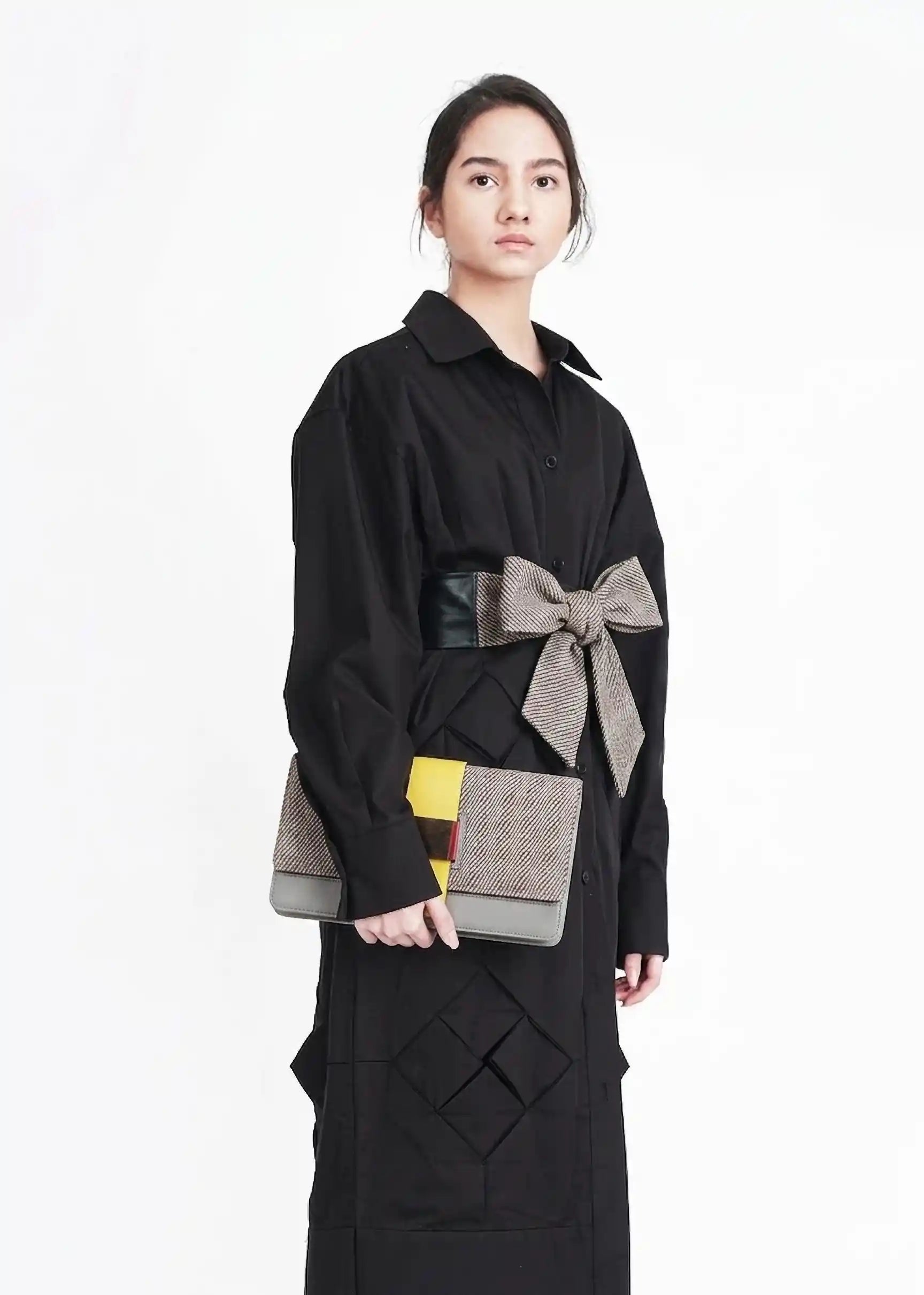 Woman carrying Berlin Clutch Rise Sandstone handwoven cotton clutch with multi color leather