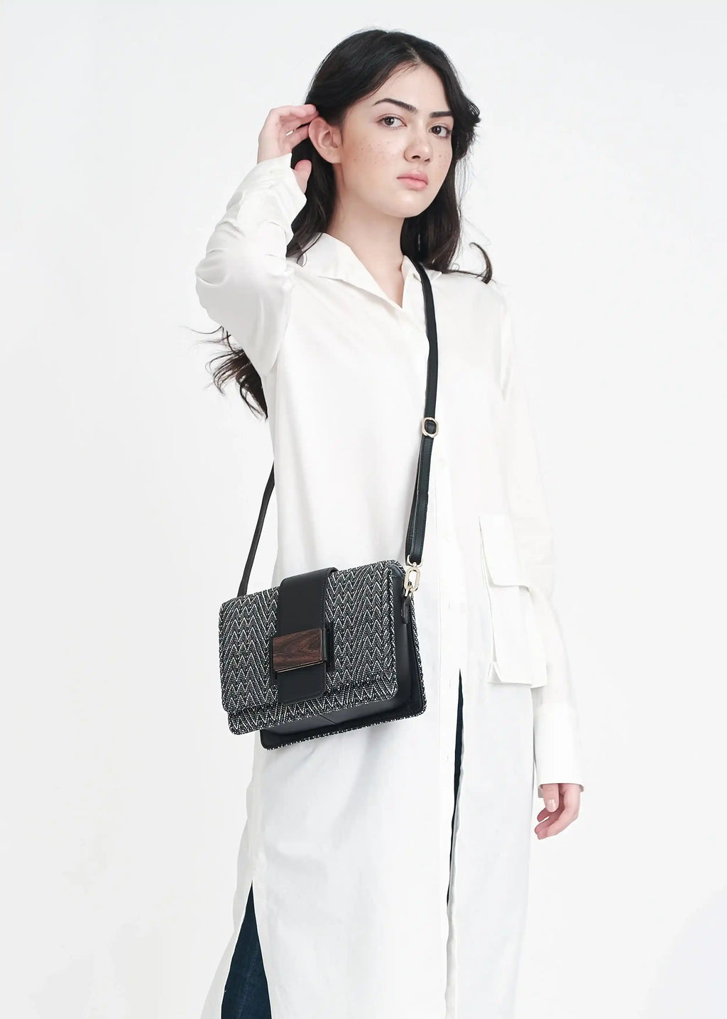 Woman wearing Berlin handwoven crossbody bag in Peak Noir over shoulder