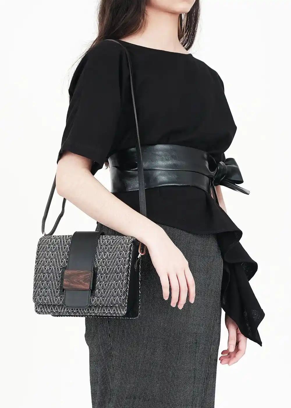 Model carrying Berlin crossbody bag in black — worn at hip level