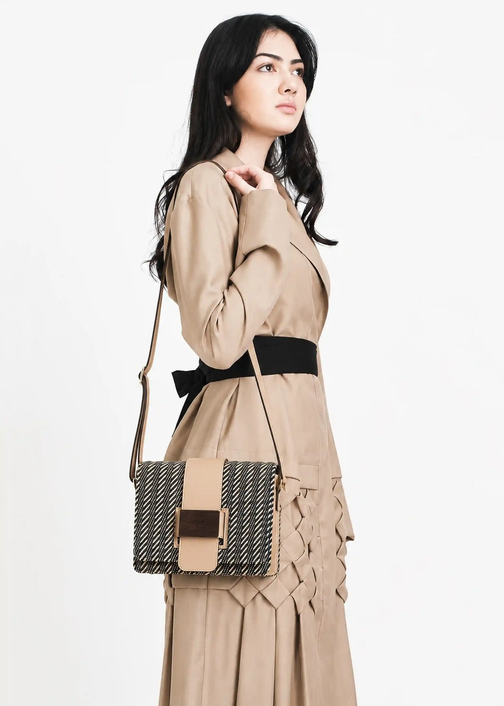 Woman wearing Berlin Twist Dusk handwoven crossbody bag with beige leather over shoulder