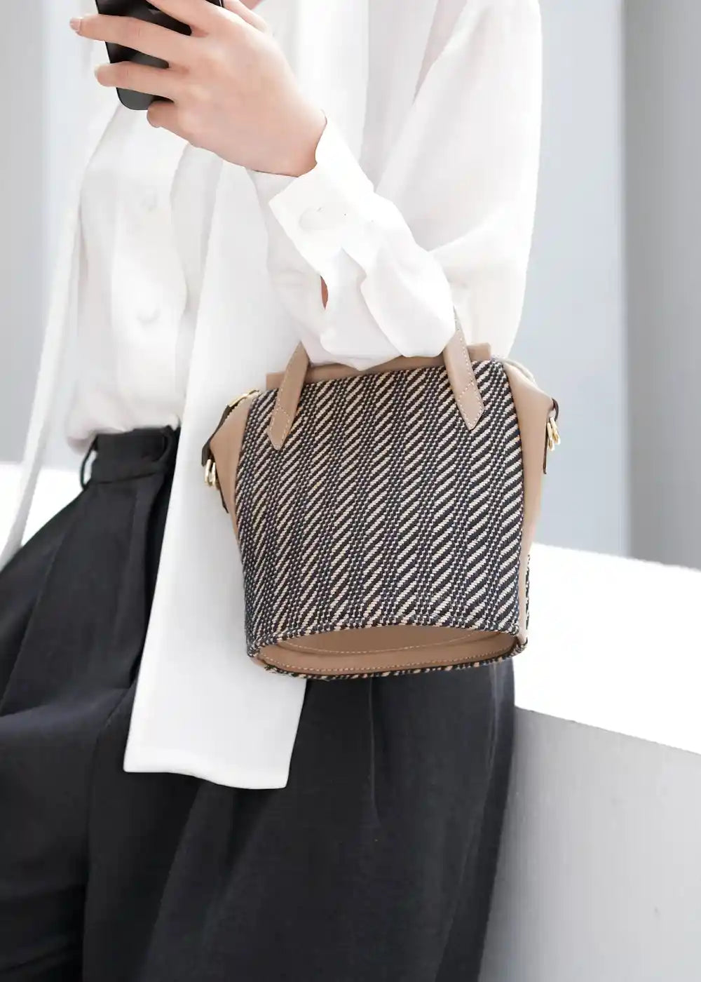 Model carrying Chicago Mini Twist Dusk bag with beige nappa leather handles