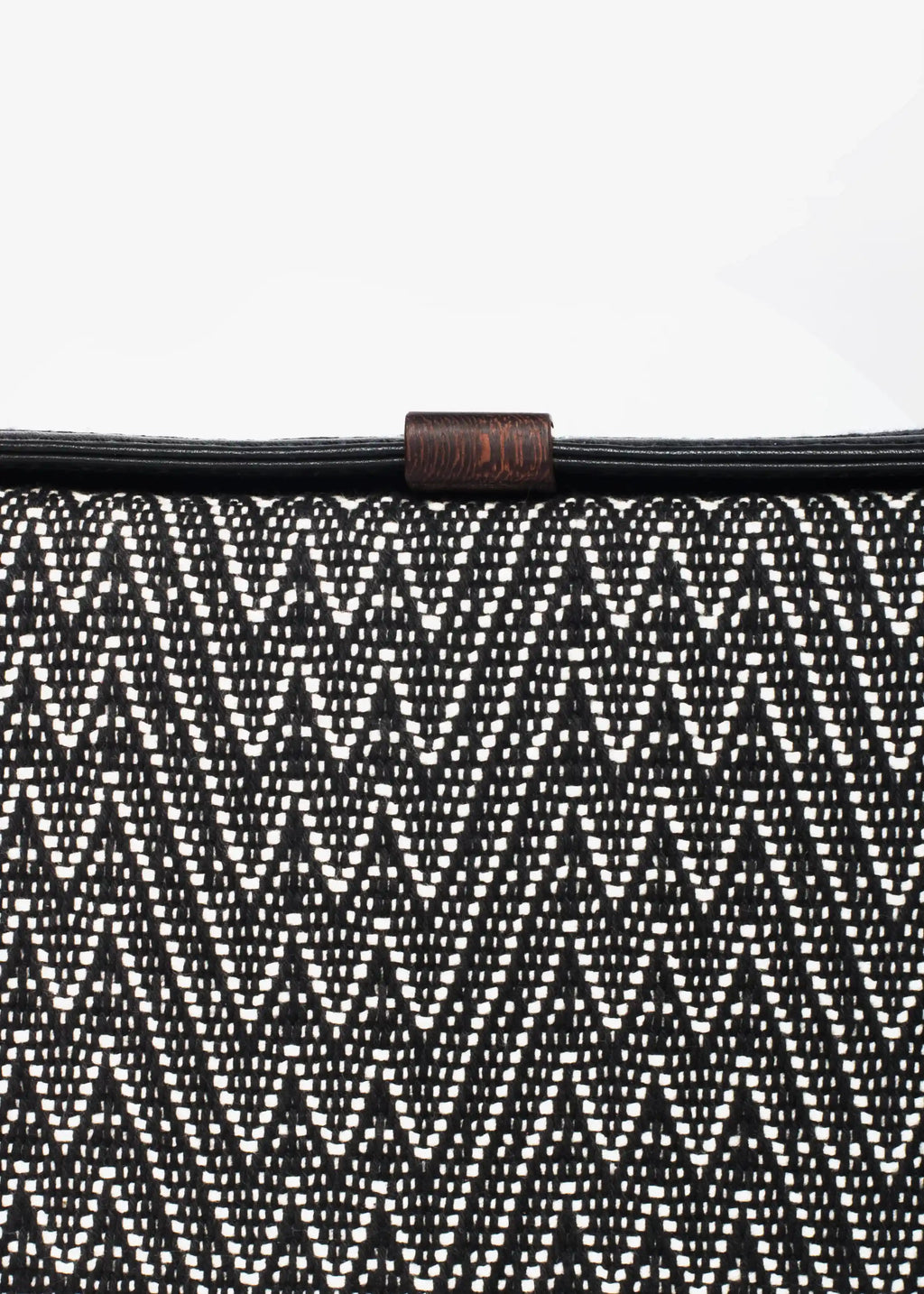 Close-up of Peak Noir handwoven cotton weave and reclaimed rosewood tab on Zürich crossbody bag
