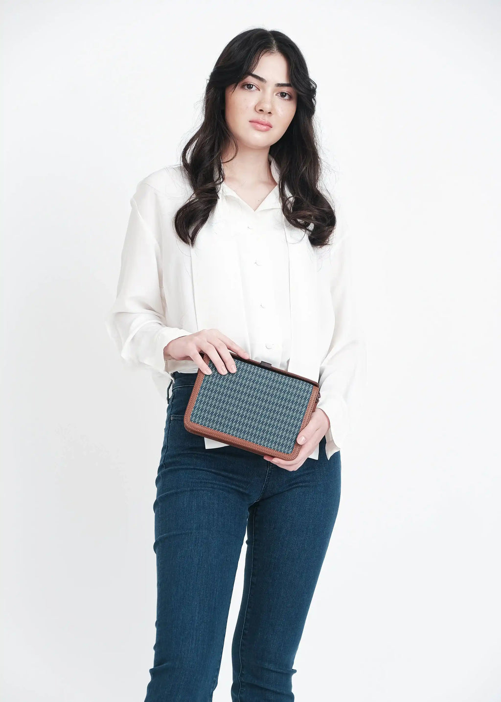 Model holding Zürich Sing Peacock crossbody bag showing full structured body