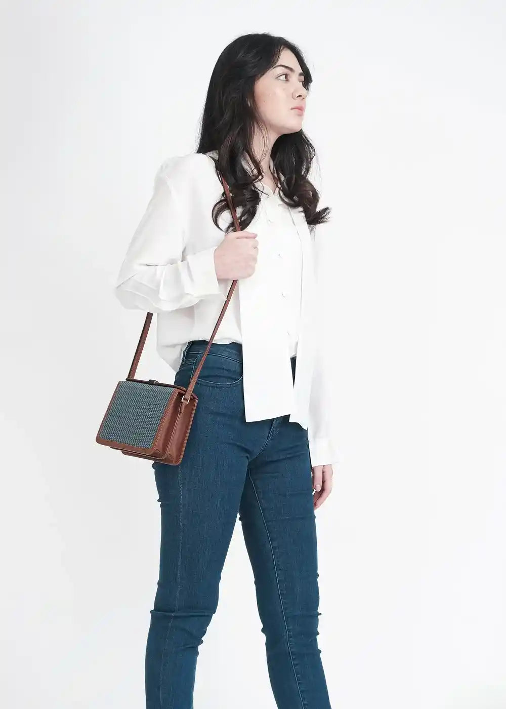 Woman wearing Zürich Sing Peacock crossbody bag with brown nappa leather over shoulder