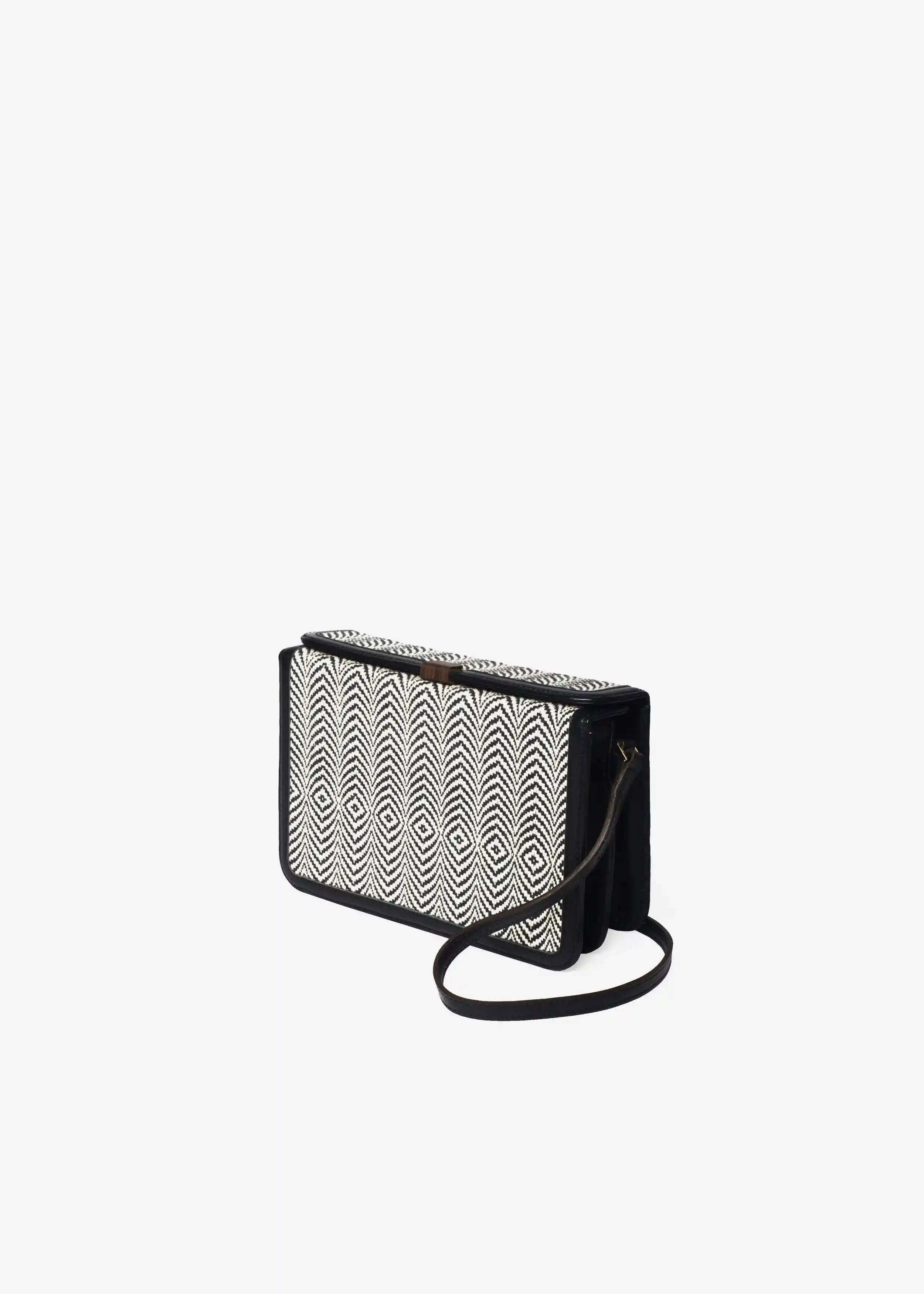 Zürich Sizzle Salt & Pepper crossbody bag angled view — compact structured body with black nappa leather and rosewood closure
